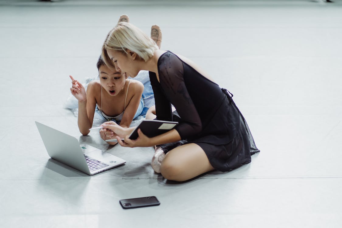 Free Impressed Asian little ballerina with instructor using laptop Stock Photo